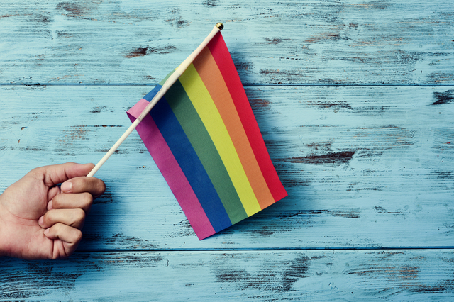 man waving a small rainbow flag