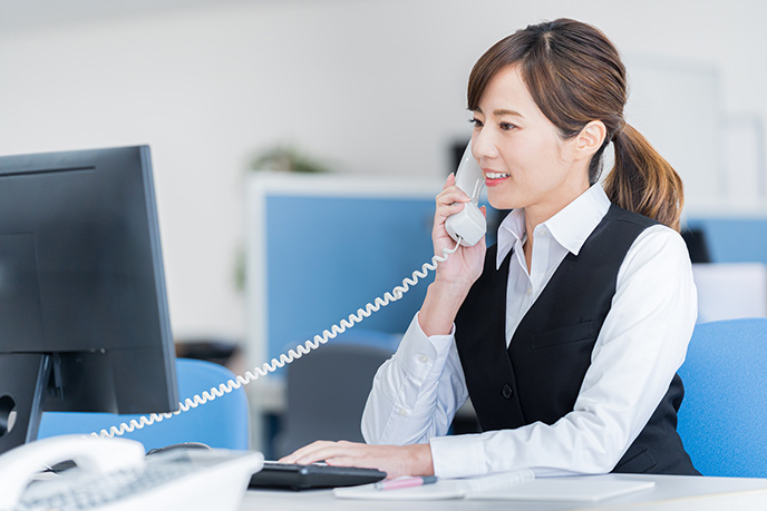 サーブコープのバイリンガル秘書と電話対応をしているレセプショニスト