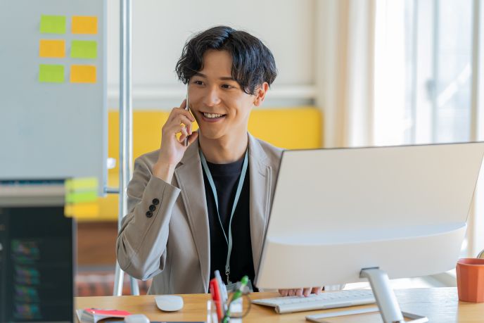 ビジネスコミュニケーションを通じて、英語での電話対応を行うビジネスパーソン