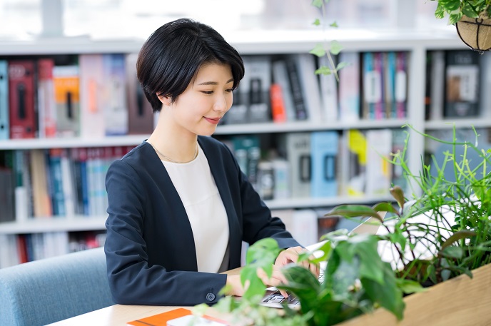 おしゃれなオフィスで仕事をする女性の画像