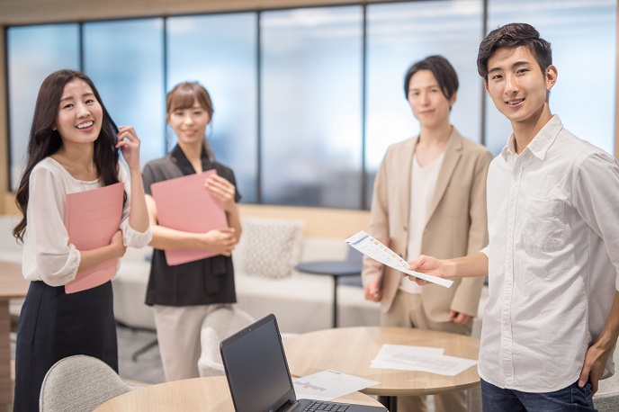 綺麗なオフィスで集まる社員の画像