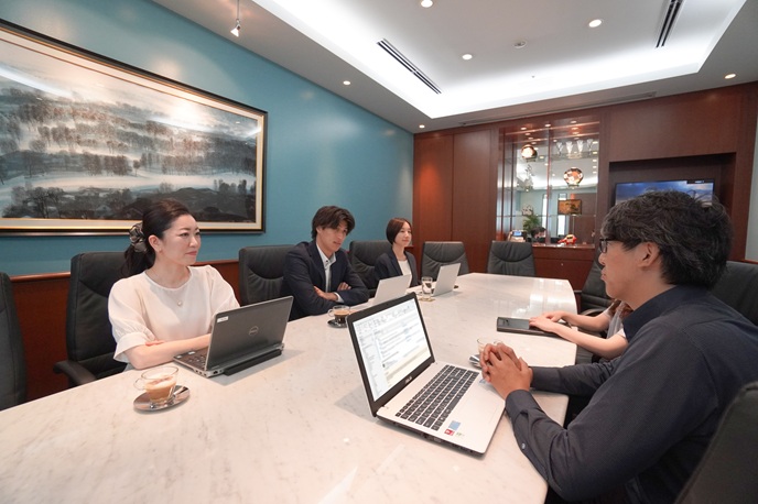 サーブコープのきれいで落ち着いた会議室で会議をするビジネスパーソン