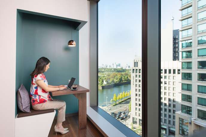 眺めのいいコワーキングスペースで働く女性