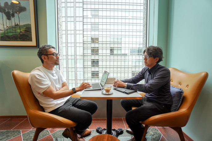 コワーキングスペースで話す2人の男性