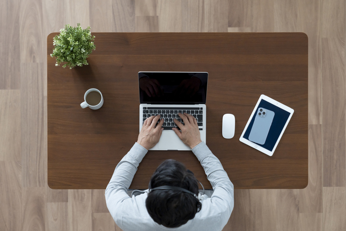 テーブルでパソコンを使っている男性