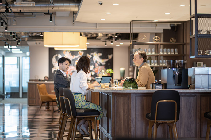 サーブコープヤンマー東京のキッチンスペースでコーヒーを飲みながら会議をする利用者