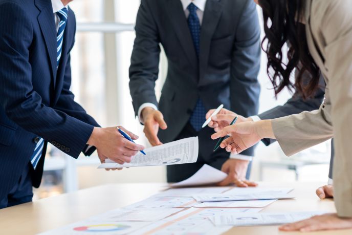 起業や開業時に、ビジネスの早期立ち上げや経費削減について会議する4人のビジネスパーソン