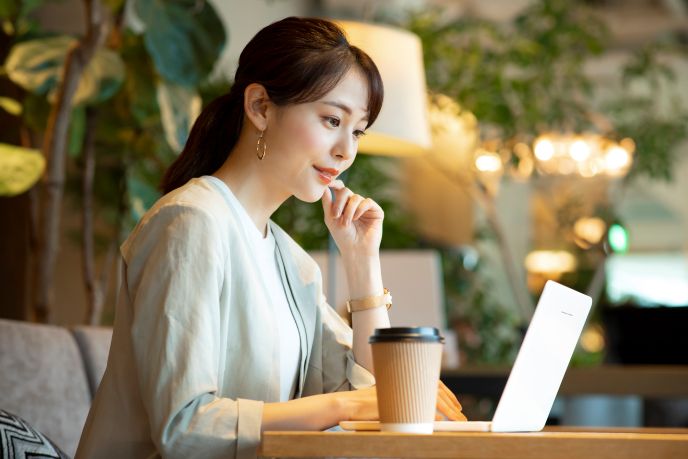 コワーキングスペースでパソコン画面を見ながら作業する女性起業家の様子