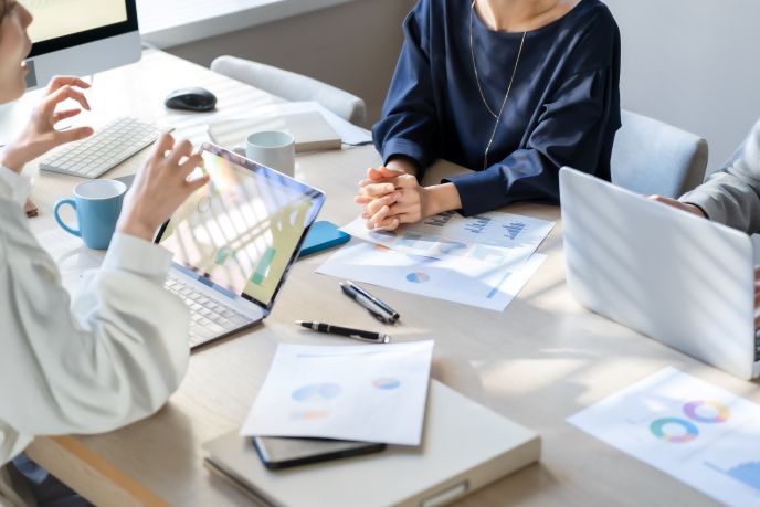 AIを活用した業務効率化について、企業の担当者が会議室で打ち合わせをしている様子