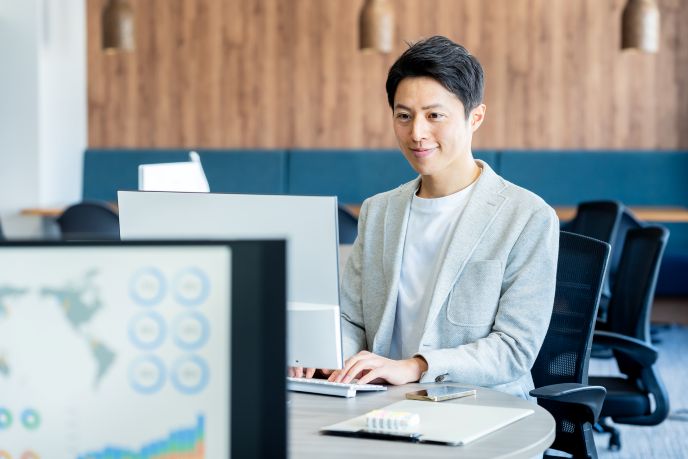 コワーキングスペースで集中してパソコン作業をする男性