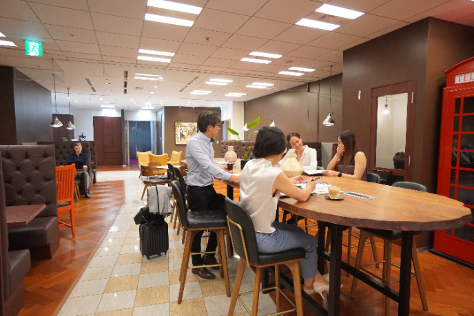 サーブコープのラウンジで和やかに話しながらビジネス住所やオフィスを選ぶ個人事業主