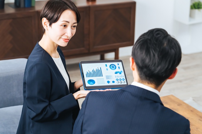 タブレットで資料を提示しながら説明するビジネスパーソン